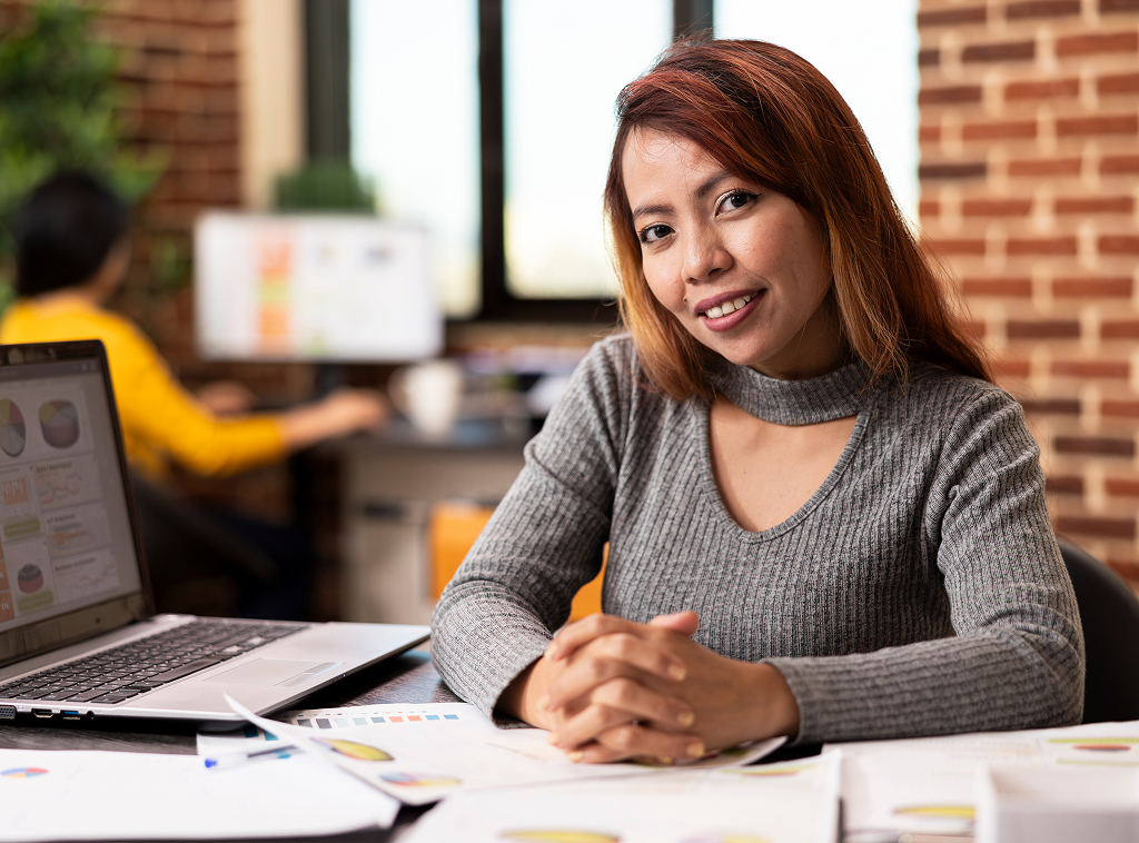 Confident Asian woman smiling at the camera in a professional office setting